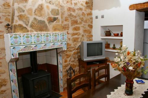 - un salon avec une cuisinière et une télévision dans l'établissement Casa La Vileta - Turistrat, à Albocácer