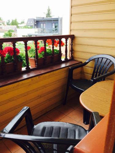 a balcony with tables and chairs and flowers on a window at Lana House in Pärnu