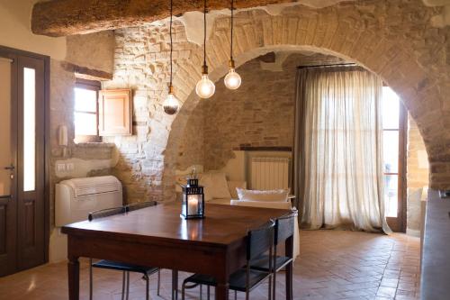 a dining room with a table and a stone wall at Umbria Country Shelter in Compignano