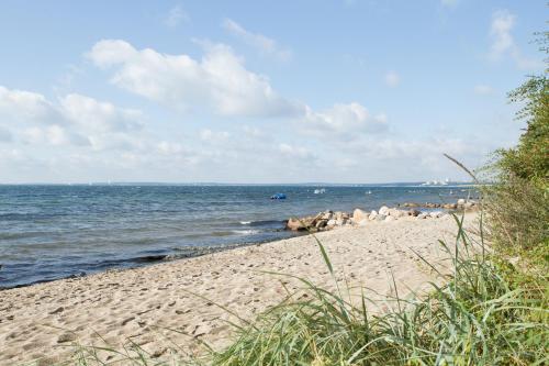 a sandy beach with a view of the ocean at Familotel Strandkind in Pelzerhaken