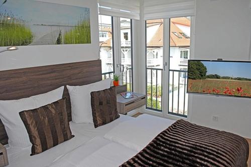 ビンツにあるVilla Poseidon mit Balkonのベッドルーム1室(ベッド1台、大きな窓付)