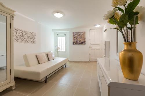 - un salon avec un canapé et un vase fleuri dans l'établissement A lovely split level townhouse in the heart of Cannes next to the Marche Forville and the Palais 1749, à Cannes
