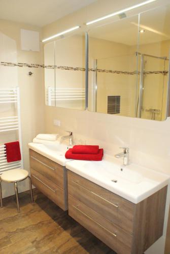 uma casa de banho com 2 lavatórios e uma toalha vermelha em Singerhof em Fulpmes