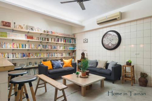a living room with two couches and a clock on the wall at Home In Tainan in Tainan