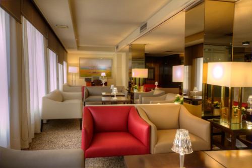 a living room with couches and a red chair at Hotel Royal Plaza in Ibiza Town
