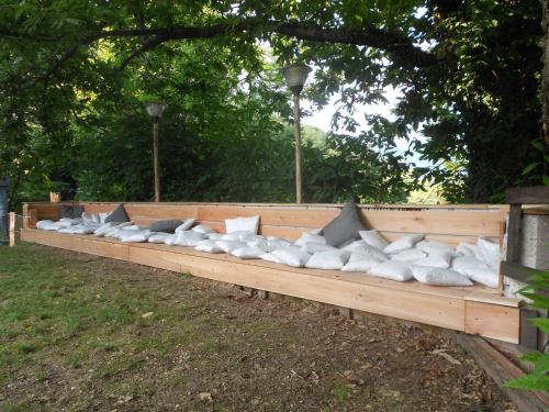 a row of white pillows sitting on a wooden bench at Biss Badaliss - Bed & Breakfast in Valdobbiadene