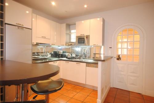 une cuisine avec des armoires blanches et une table dans l'établissement Grand Palais 4P BOB1309, à Cannes