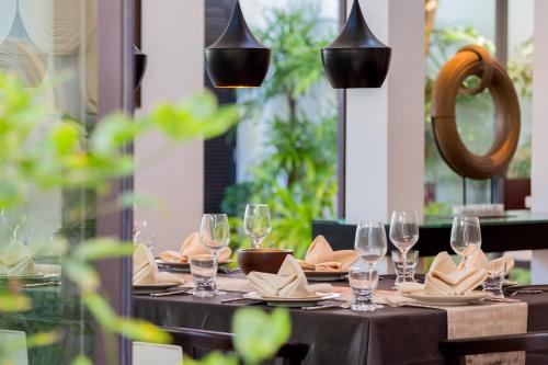 a table with wine glasses and napkins on it at Beachfront Villa Baan Paradise in Laem Set Beach