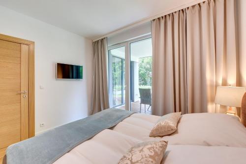 a bedroom with a bed and a large window at INA Rent - Tre Mare Apartamenty in Gdańsk