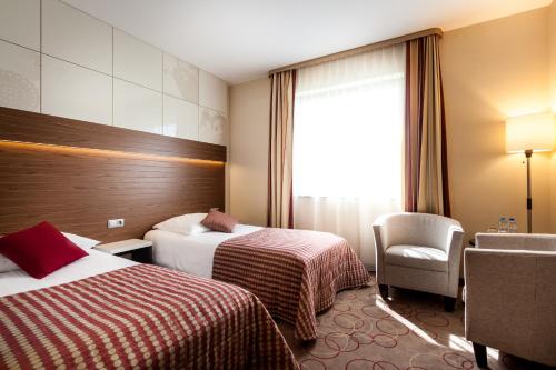 a hotel room with two beds and a window at Qubus Hotel Kraków in Kraków