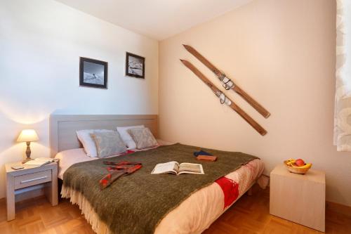 a bedroom with a bed with skis on the wall at Résidence Néméa Les Chalets Des Cîmes in La Toussuire