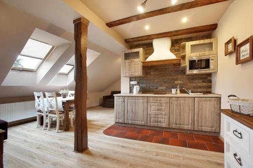 una cucina con armadi in legno e una sala da pranzo di Bocianówka z sauną i fotelem masującym w cenie a Ustroń