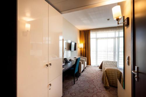 a hotel room with a bed and a desk at Qubus Hotel Kraków in Kraków