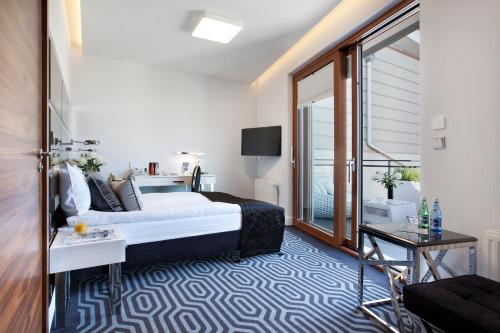 a hotel room with a bed and a balcony at Bayjonn Boutique Hotel in Sopot