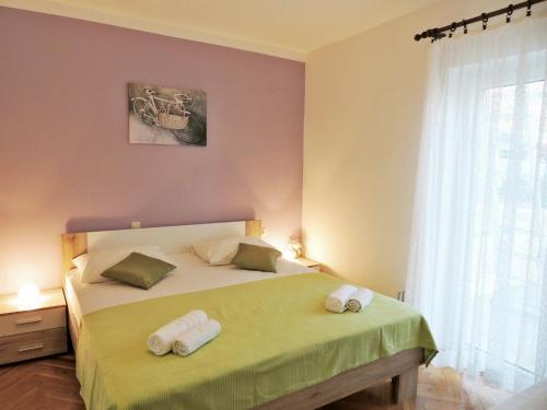 a bedroom with a bed with two towels on it at Apartments Jelena in Pag