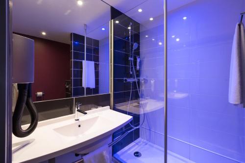 une salle de bain avec un lavabo et une douche en verre dans l'établissement ibis Styles Blois Centre Gare, à Blois