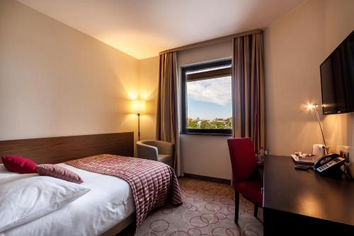a hotel room with a bed and a window at Qubus Hotel Kraków in Kraków