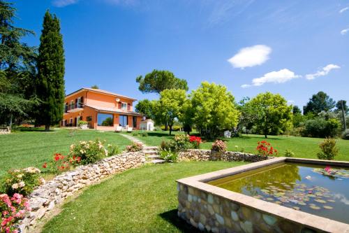 a house with a pond in front of a yard at Bellafiora Affittacamere in Osimo