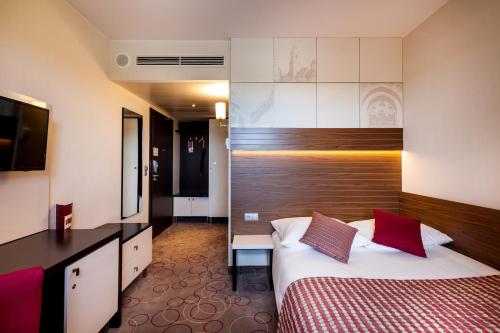 a hotel room with a bed and a television at Qubus Hotel Kraków in Kraków