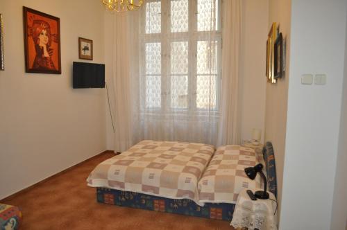 a bedroom with a bed in front of a window at Apartment Josef in Prague