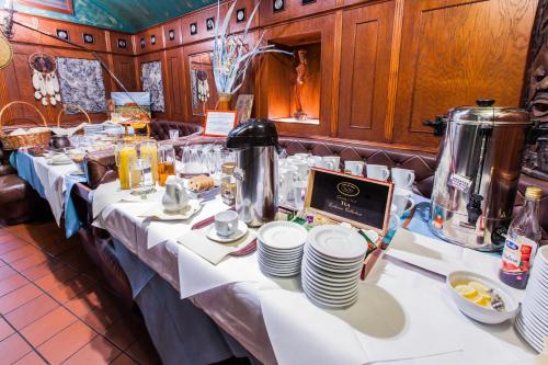 a long table with plates and a laptop on it at Jordan Pokoje Gościnne in Kraków