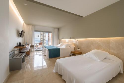 a hotel room with two beds and a balcony at Climia Belroy 4 Sup in Benidorm