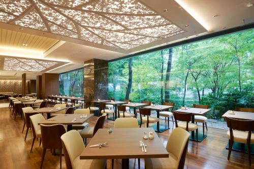 a restaurant with tables and chairs and a large window at Keio Plaza Hotel Tokyo Premier Grand in Tokyo