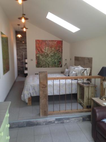 1 dormitorio con 1 cama y una pintura en la pared en Pinetree Lodge Druridge Bay, en Amble