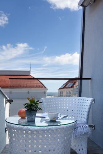 a table and chairs on a balcony with a view of the ocean at Bayjonn Boutique Hotel in Sopot