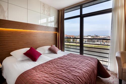 a hotel room with a bed and a large window at Qubus Hotel Kraków in Krakow