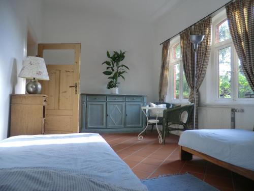 sypialnia z łóżkiem, biurkiem i oknami w obiekcie Fachwerkhaus Julius w mieście Lehrte