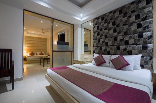 a bedroom with a large bed and a living room at Hotel Krishna Deluxe-By RCG Hotels in New Delhi