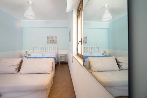 アルカモ・マリーナにあるHelios Casa Vacanzeのベッド2台と窓が備わる客室です。