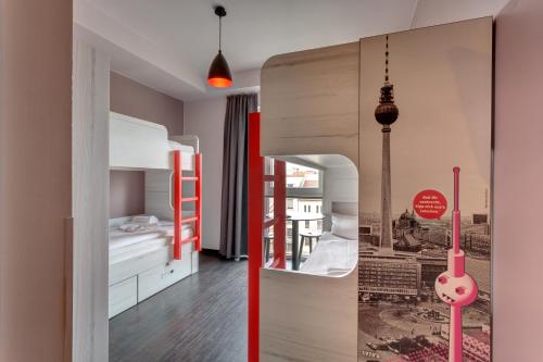 Habitación con litera y dormitorio con espejo. en MEININGER Hotel Berlin Alexanderplatz, en Berlín