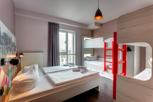 a bedroom with a bunk bed and a red ladder at MEININGER Hotel Berlin Alexanderplatz in Berlin