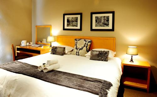 a bedroom with a large white bed and a desk at Villa Paradiso in Hartbeespoort
