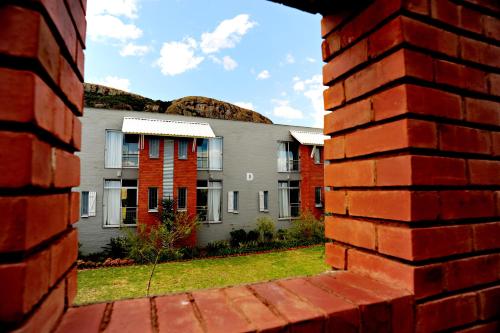a view of a building through a brick wall at Villa Paradiso in Hartbeespoort