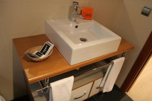a bathroom sink on a wooden counter with towels at Apartaments Independencia in Barcelona