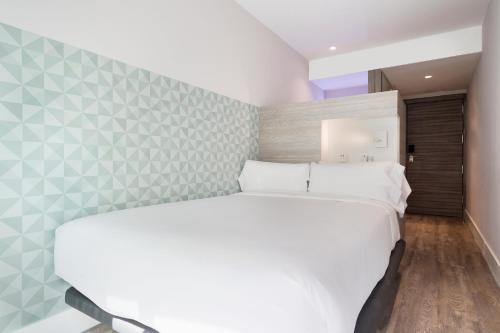 A bed or beds in a room at Niu Barcelona Hotel