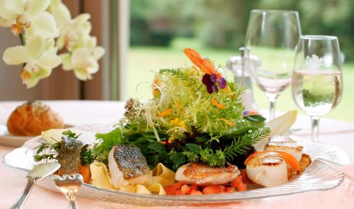 a plate of food on a table with wine glasses at Concorde Sfax Centre in Sfax