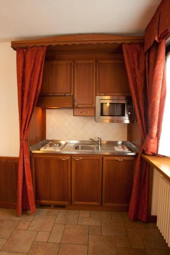 a kitchen with a sink and a microwave at Residence Le Grand Chalet in Courmayeur