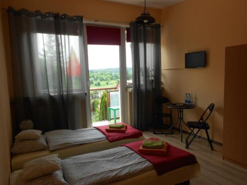 a bedroom with two beds and a large window at Extra Pokoje do Wynajęcia in Kraków