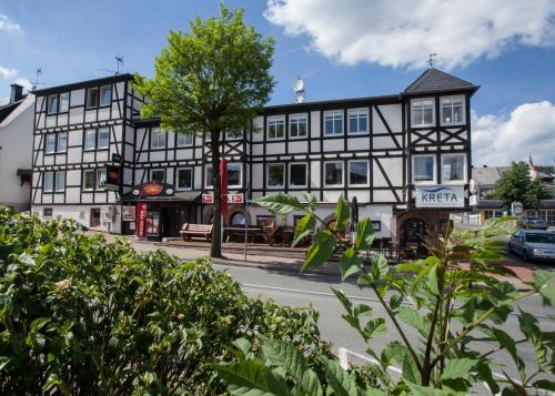 a black and white building on the corner of a street at Landhaus Wiesemann Parkappartements & Dependance - Nähe Ettelsberg-Talstation in Willingen