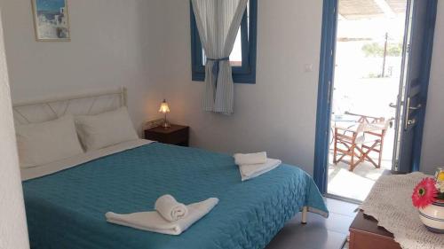 1 dormitorio con 1 cama con toallas en Artemis Rooms, en Chora Folegandros