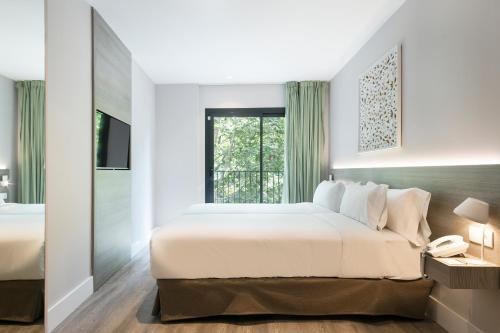 a bedroom with a large bed and a window at Niu Barcelona Hotel in Barcelona
