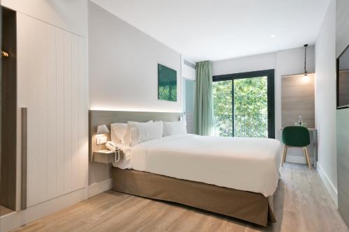 فندق نيو برشلونة في برشلونة: غرفة نوم بسرير ابيض كبير ونافذة