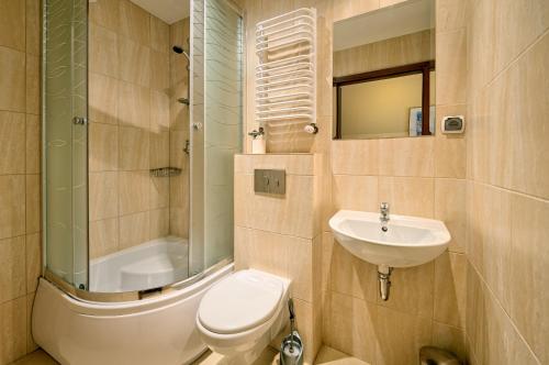 a bathroom with a toilet and a sink and a shower at Wiktoria Villa in Mielno