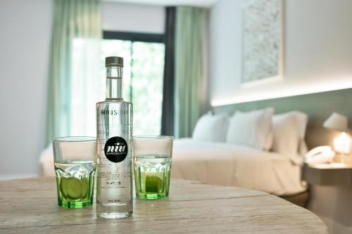 a bottle of alcohol and two glasses on a table at Niu Barcelona Hotel in Barcelona