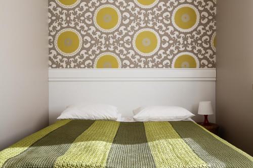 a bedroom with a bed with a yellow and green blanket at Hotel Klidzina in Skrīveri