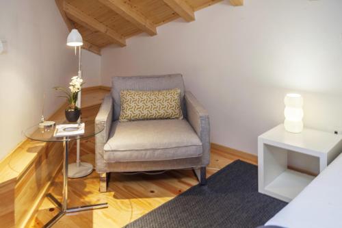 a living room with a chair and a table at BO - Almada in Porto